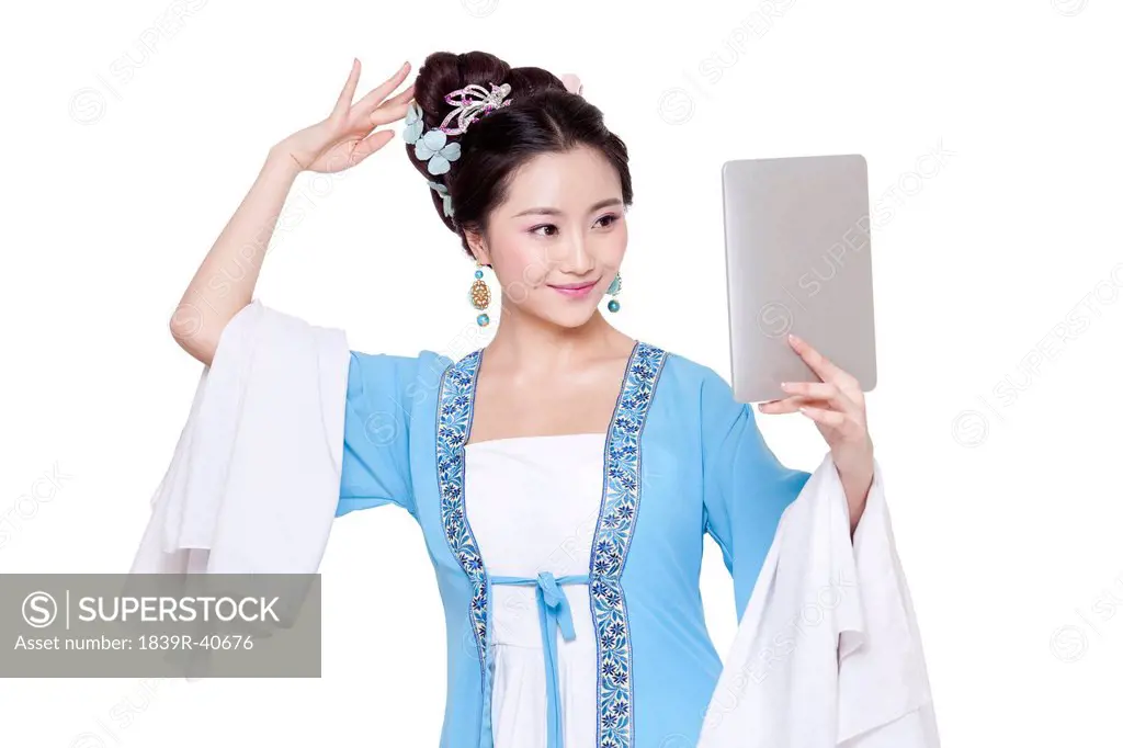 Young woman in traditional Chinese costume with digital tablet
