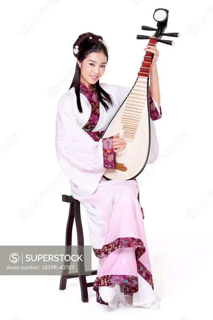 Young woman in Chinese traditional costume plucking Chinese lute