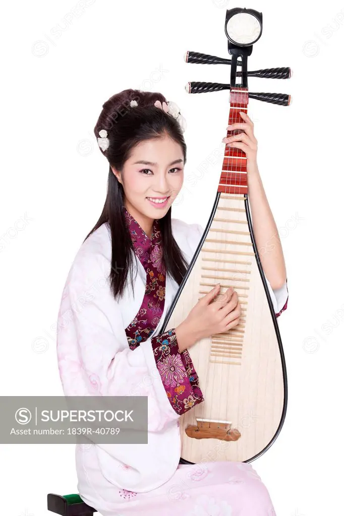 Young woman in Chinese traditional costume plucking Chinese lute