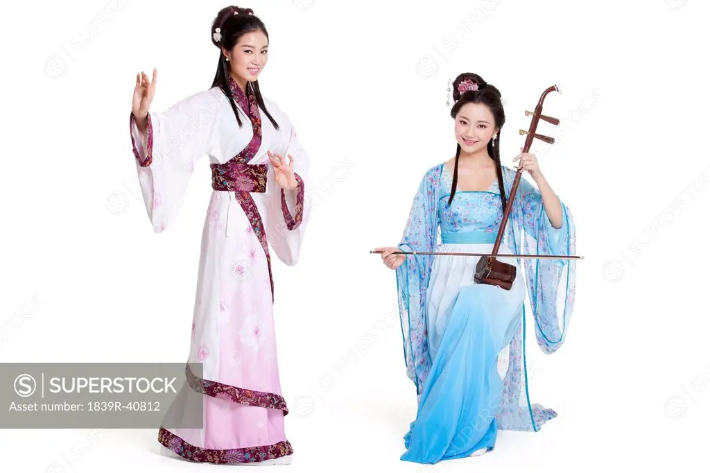 Young women in Chinese traditional costume plucking Erhu and dancing