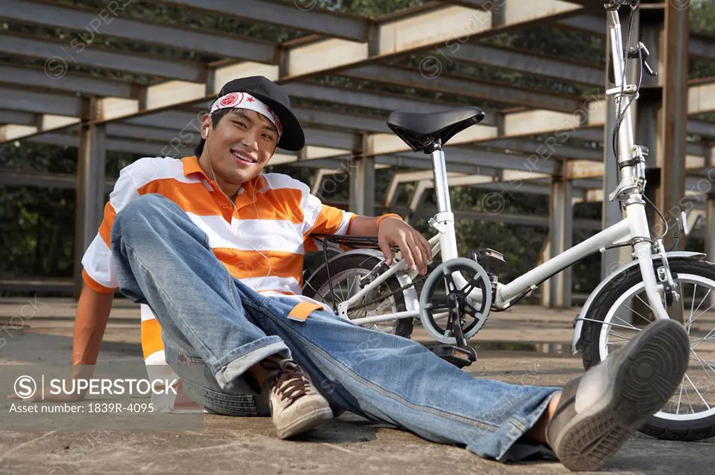 Man Sitting Down Next To Bike