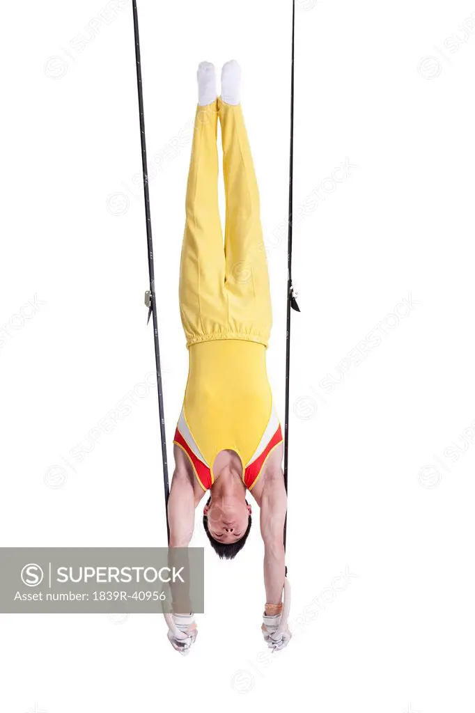 Gymnastic athlete upside down on the rings