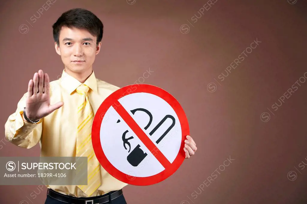 Young Man Holding A No Smoking Sign