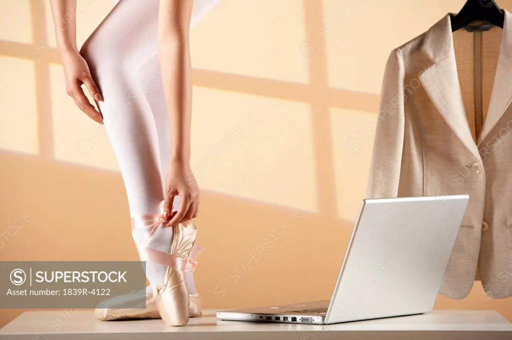 Ballet Dancer Tying Up Pointe Shoes