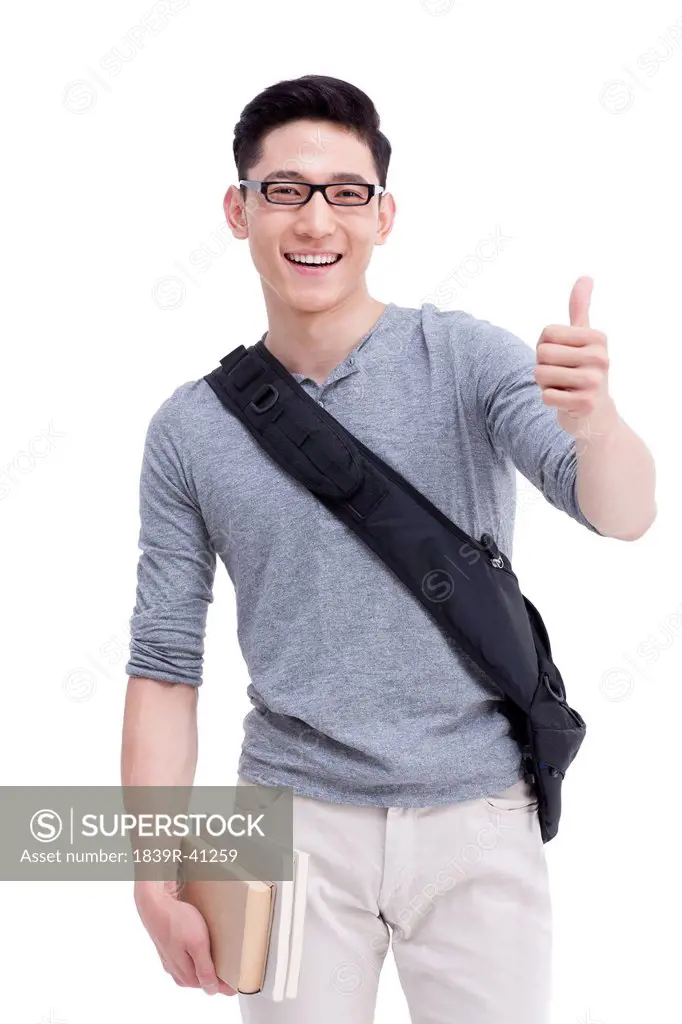 Cheerful male college student doing thumbs up