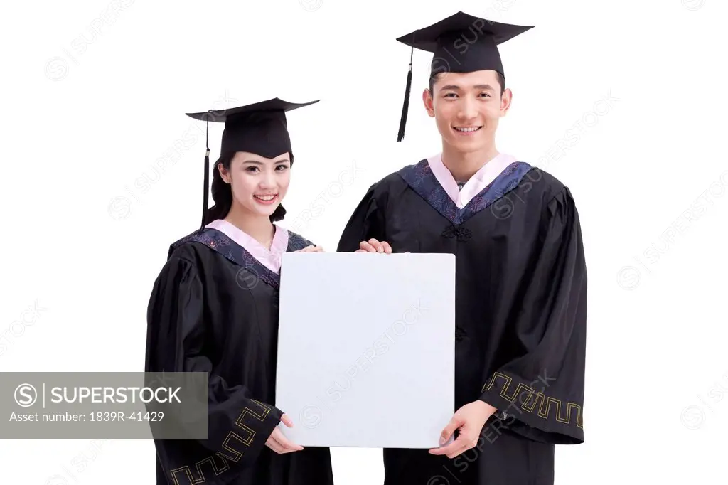 Happy college graduates with whiteboard