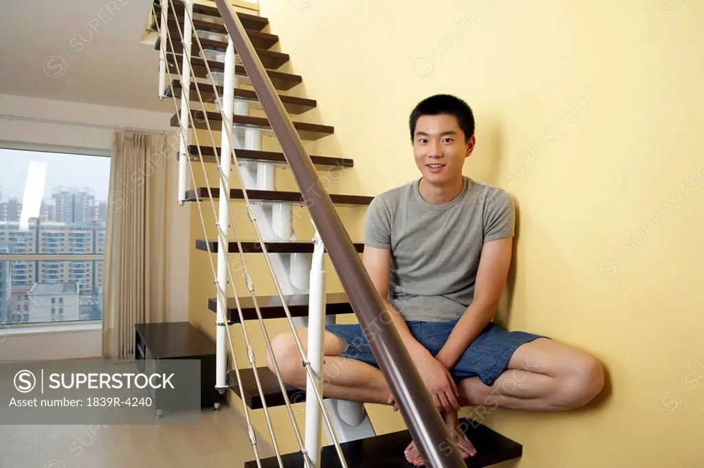 Portrait Of Young Man Sitting On Staircase