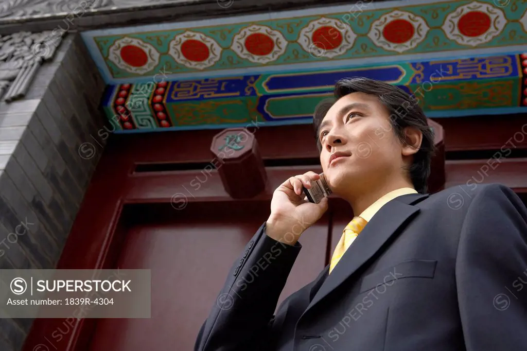 Businessman Talking On Cellphone Outside The Forbidden City In Beijing