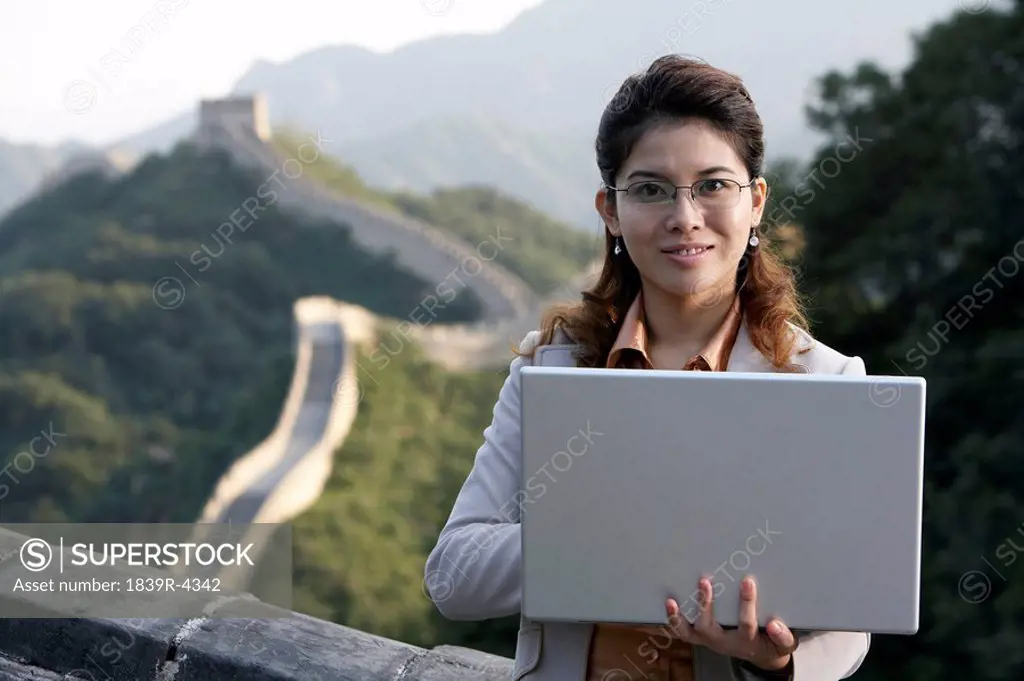 Businesswoman Typing On Laptop Computer On The Great Wall Of China