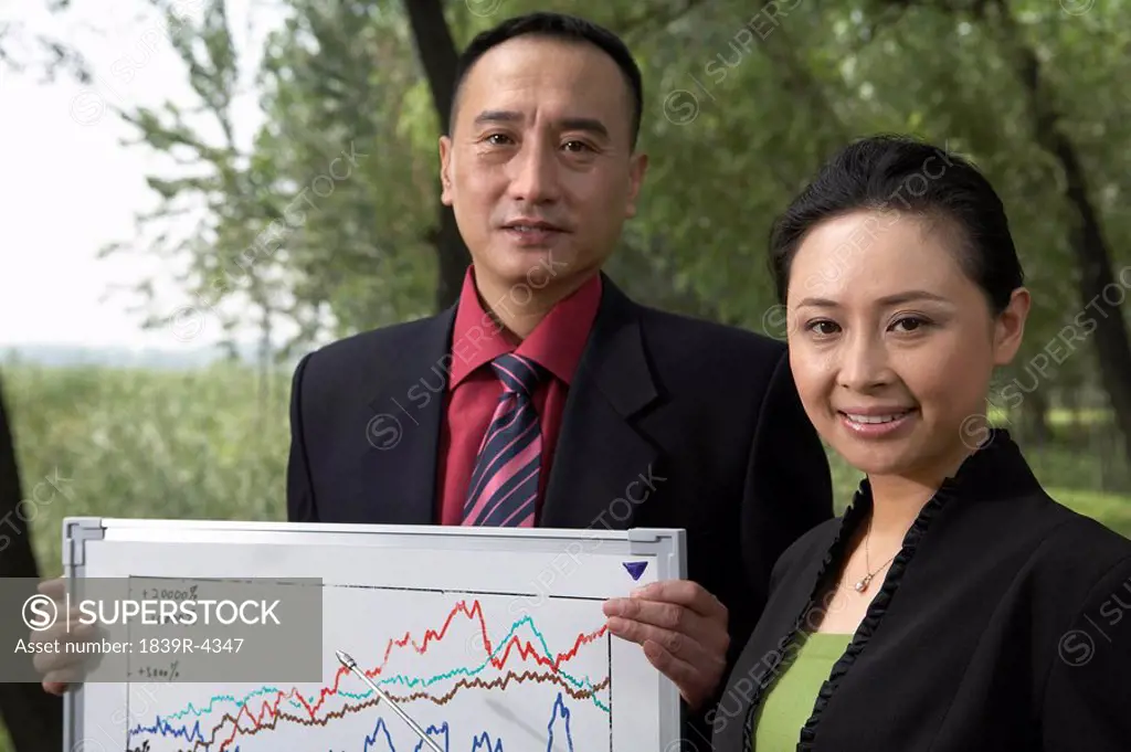 Businesswoman And Man Holding Stock Chart