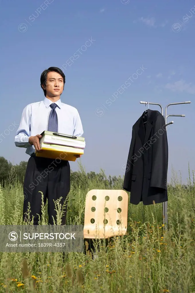 Portrait Of Businessman In A Field With Books