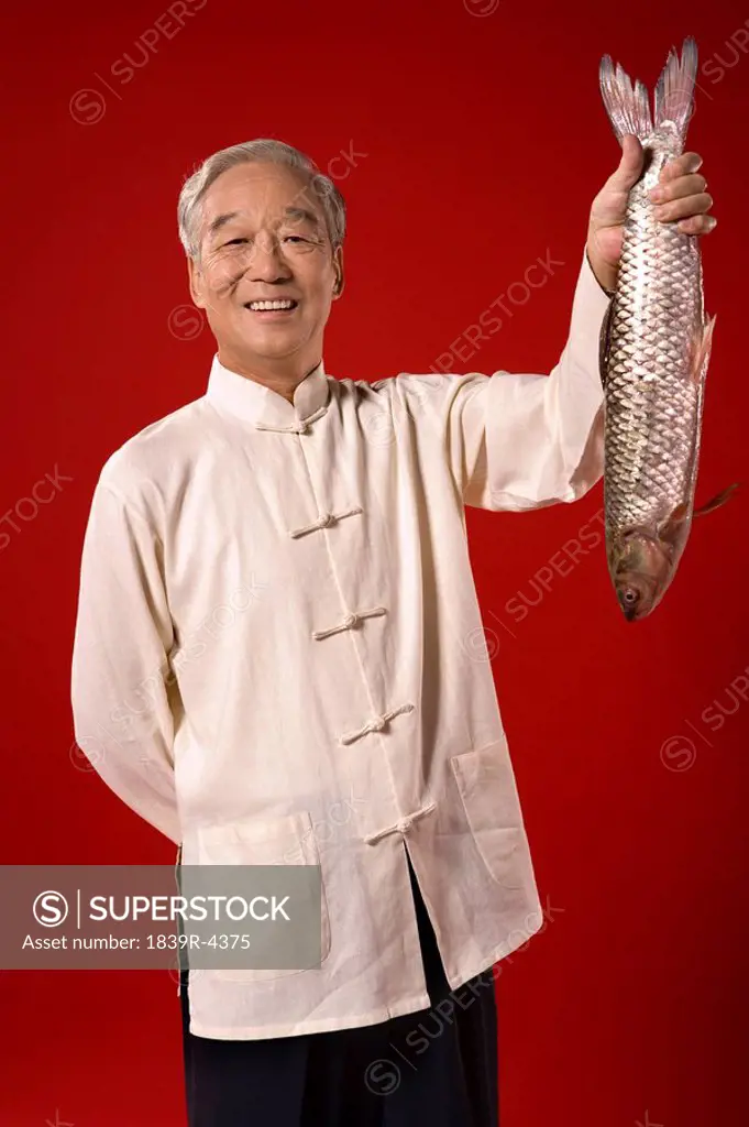 Elderly Man Showing Off Raw Fish