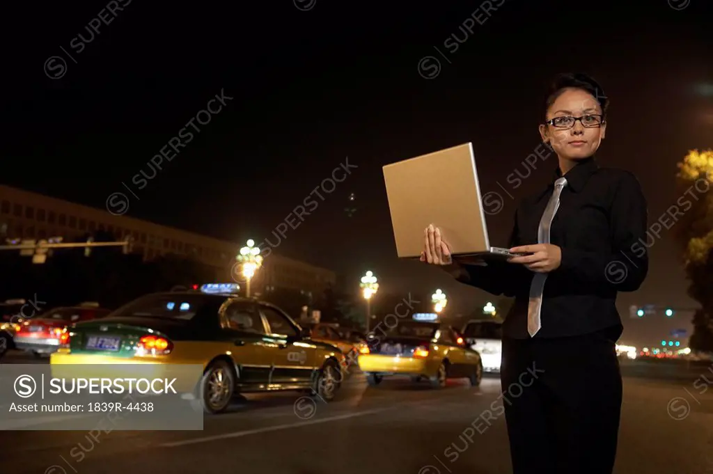 Businesswoman Using Laptop Outside At Night