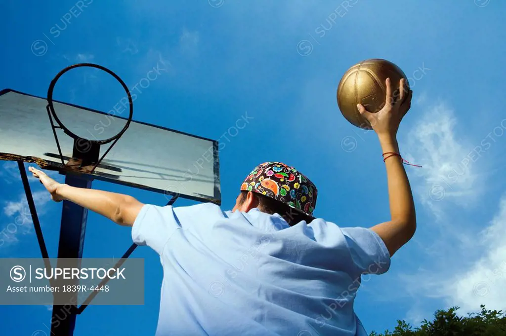 Teenage Boy Shooting Basketball At Hoop