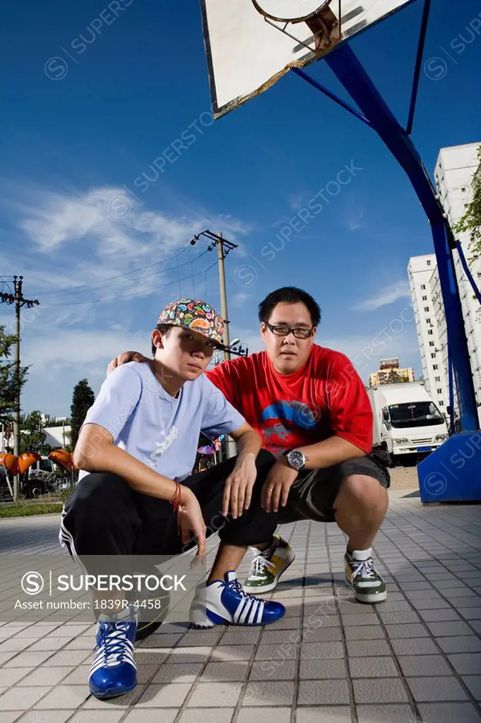 Two Boys Hanging Out On A Basketball Court