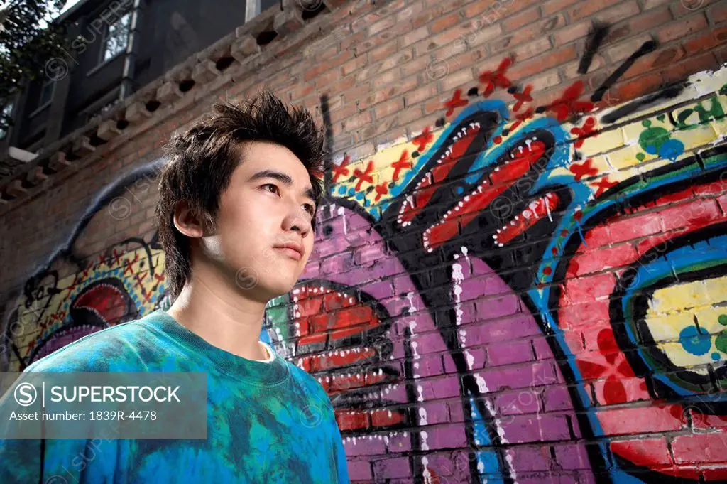Teenage Boy In Front Of A Wall Of Graffiti