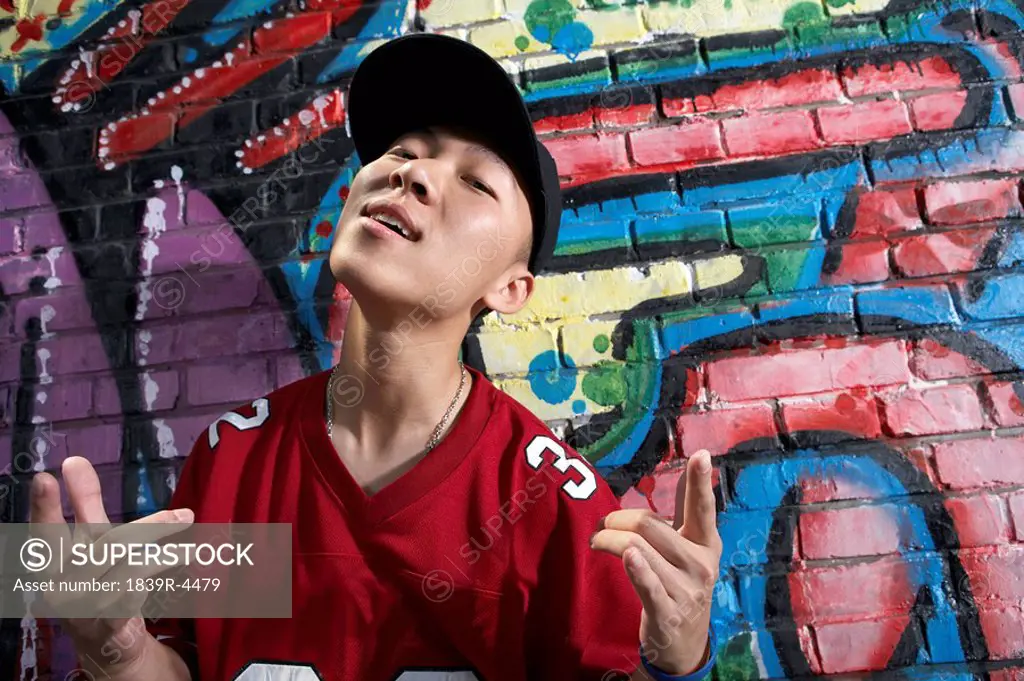 Teenage Boy Dancing In Front Of A Wall Of Graffiti