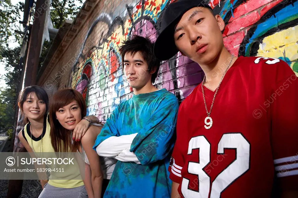 Teenagers Leaning On A Wall Of Graffiti