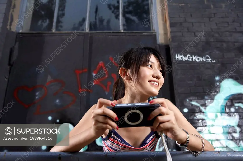 Teenage Girl Holding Personal Game Console