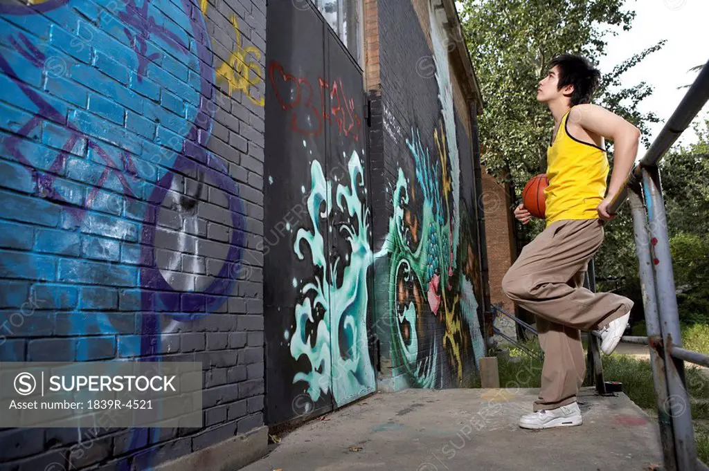 Teenage Boy Looking At Spray Painted Wall