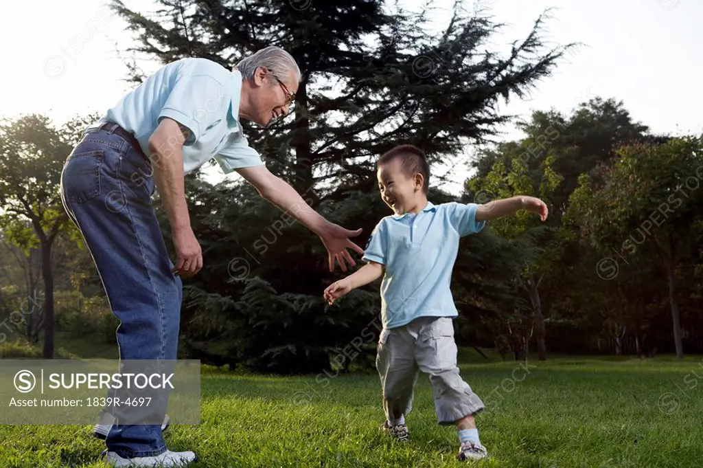 Grandfather And His Grandson Playing Together In Park