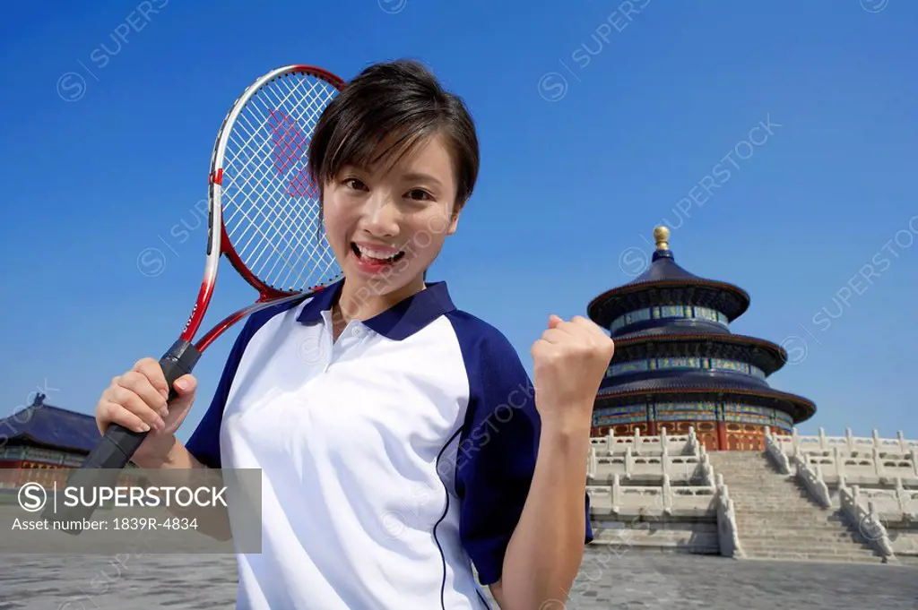Portrait Of Young Female Tennis Player In Front Of Temple