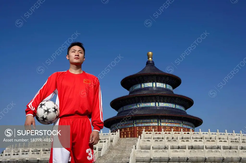 Portrait Of Young Male Soccer Player In Front Of Temple