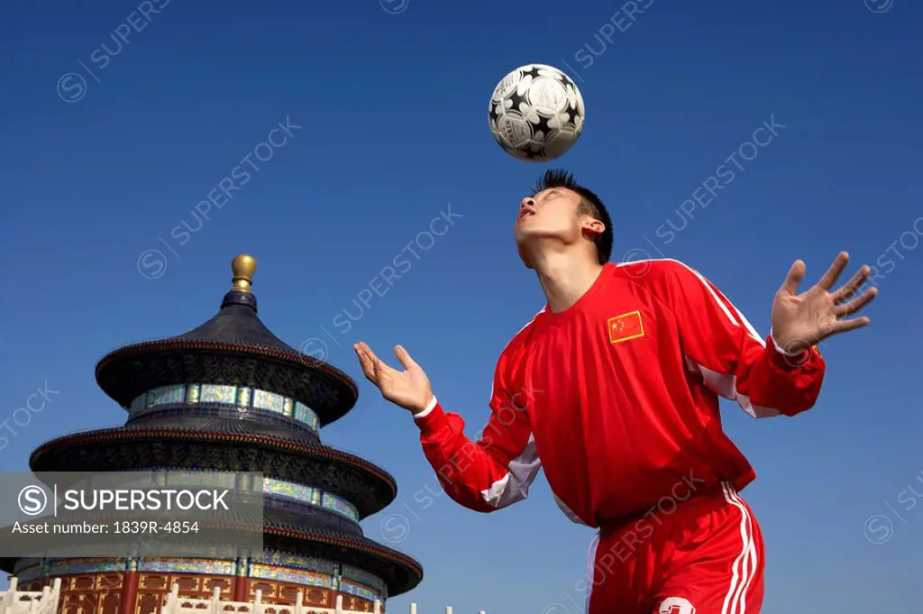 Young Male Soccer Player In Front Of Temple