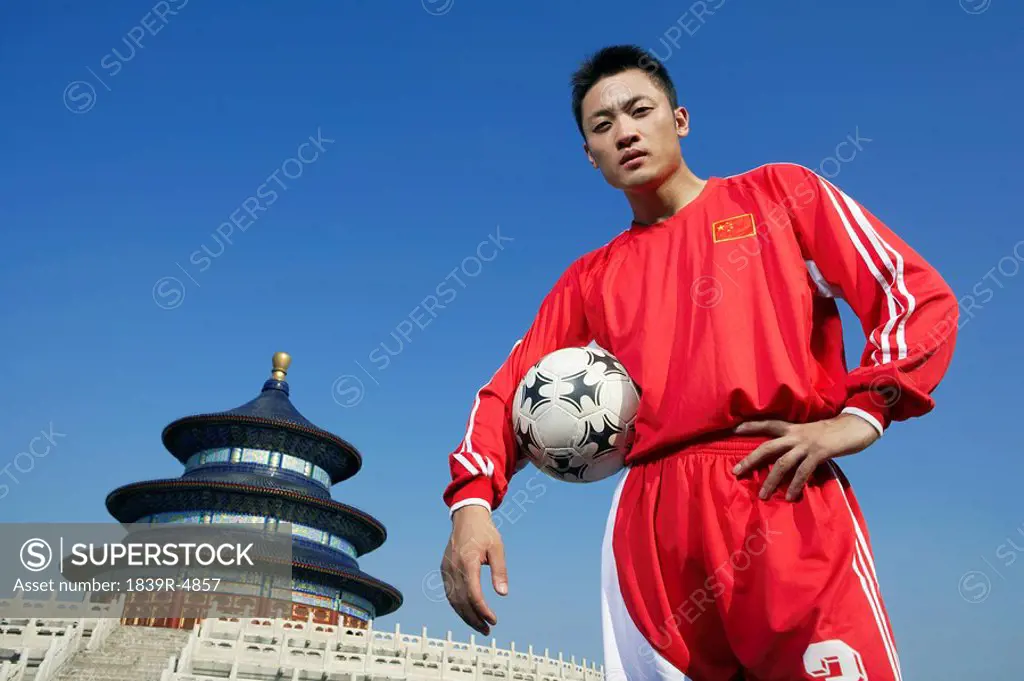 Portrait Of Young Male Soccer Player In Front Of Temple