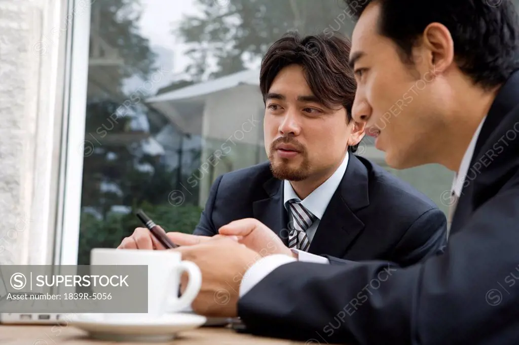 Two Businessmen Having A Meeting At A Cafe