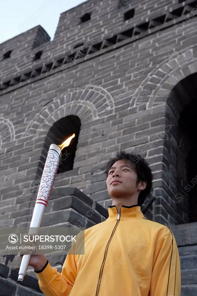 Young Man Holds Olympic Torch At The UNESCO World Heritage Site