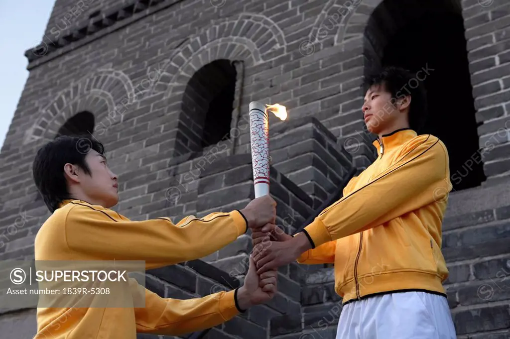 One Young Man Passes The Torch To Another Olympic Torch At The UNESCO World Heritage Site