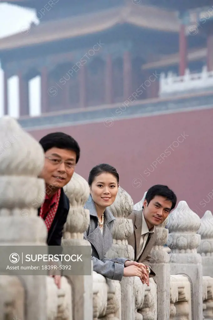 Three Business People Leaning On The Balustrades In The Forbidden City In Beijing