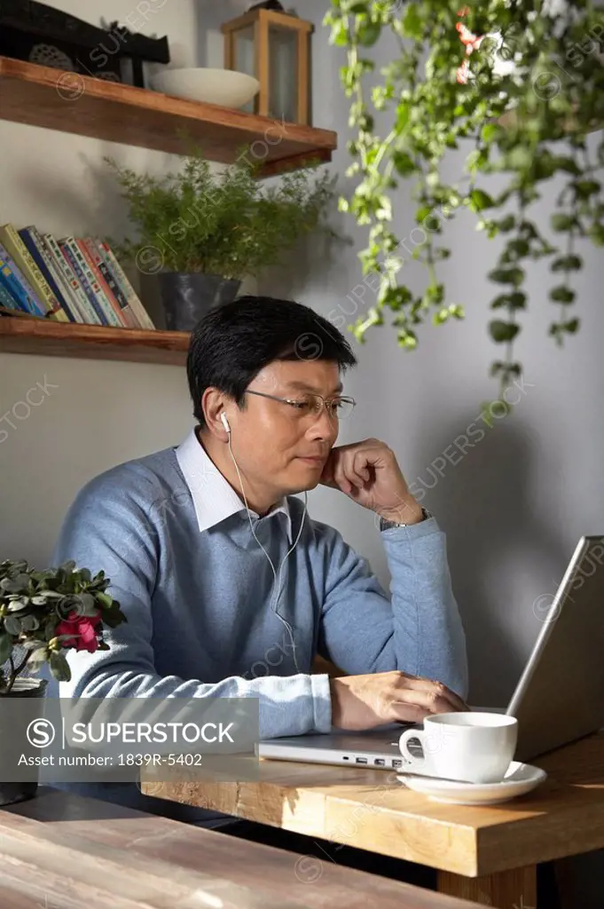 Man Using Laptop Computer With Headphones On