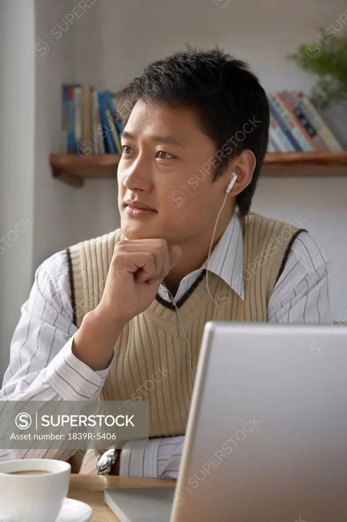 Man Using Laptop Computer With Headphones On