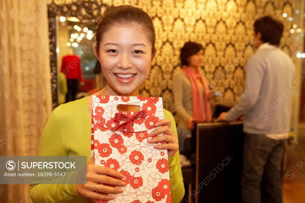 Young Woman Holding Parcel, Young Man Paying For Purchases