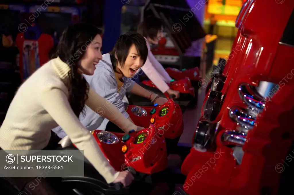 Teenagers Racing Motorbikes At Arcade