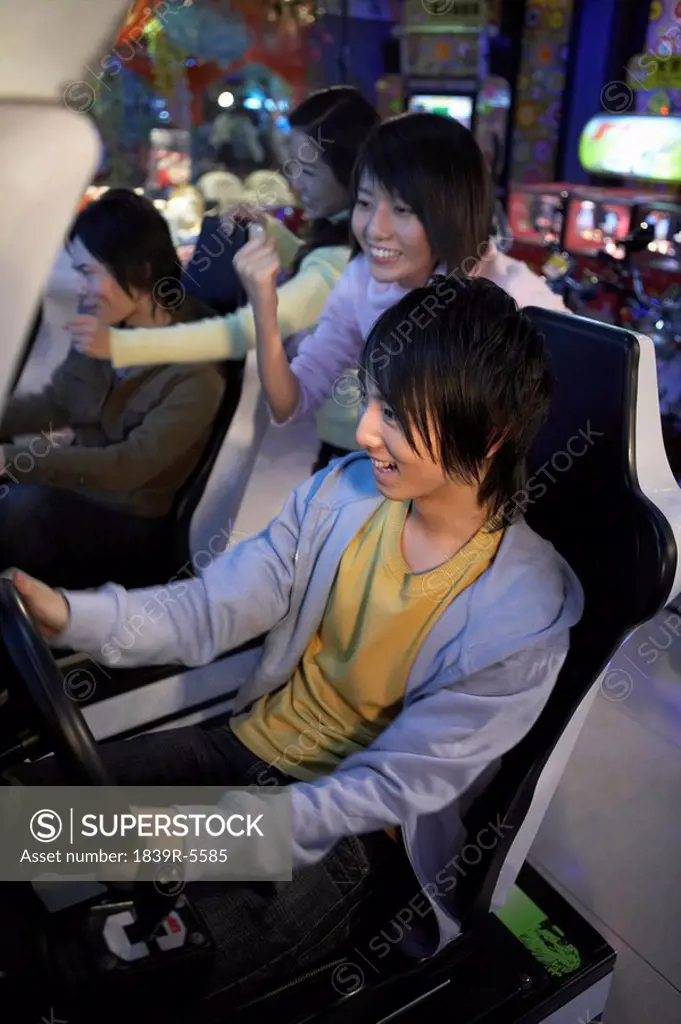 Teenagers Playing Racing Games At Arcade