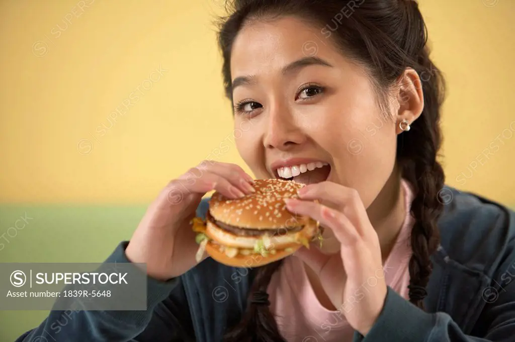 Teenage Girl Eating Hamburger