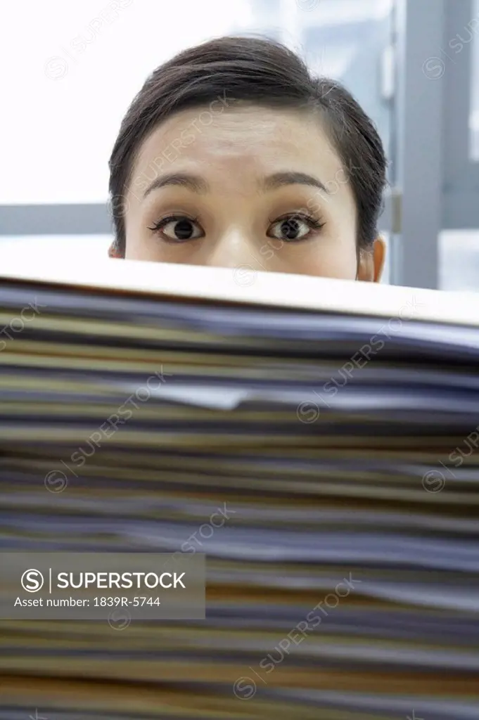 Businesswoman With Pile Of Work