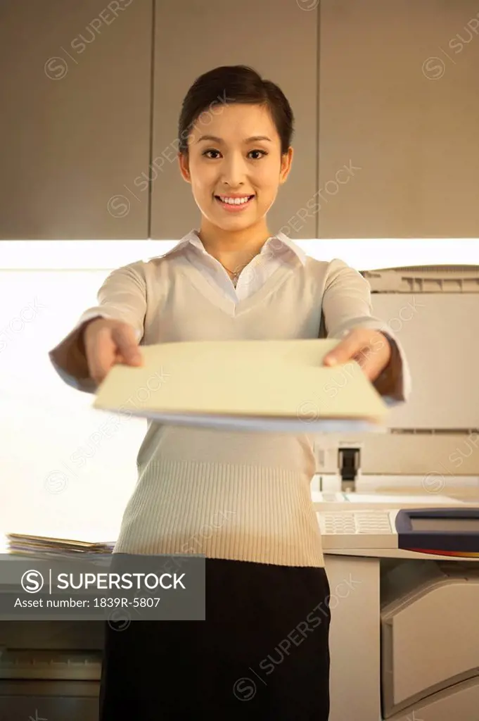 Young Woman Handing Over Documents