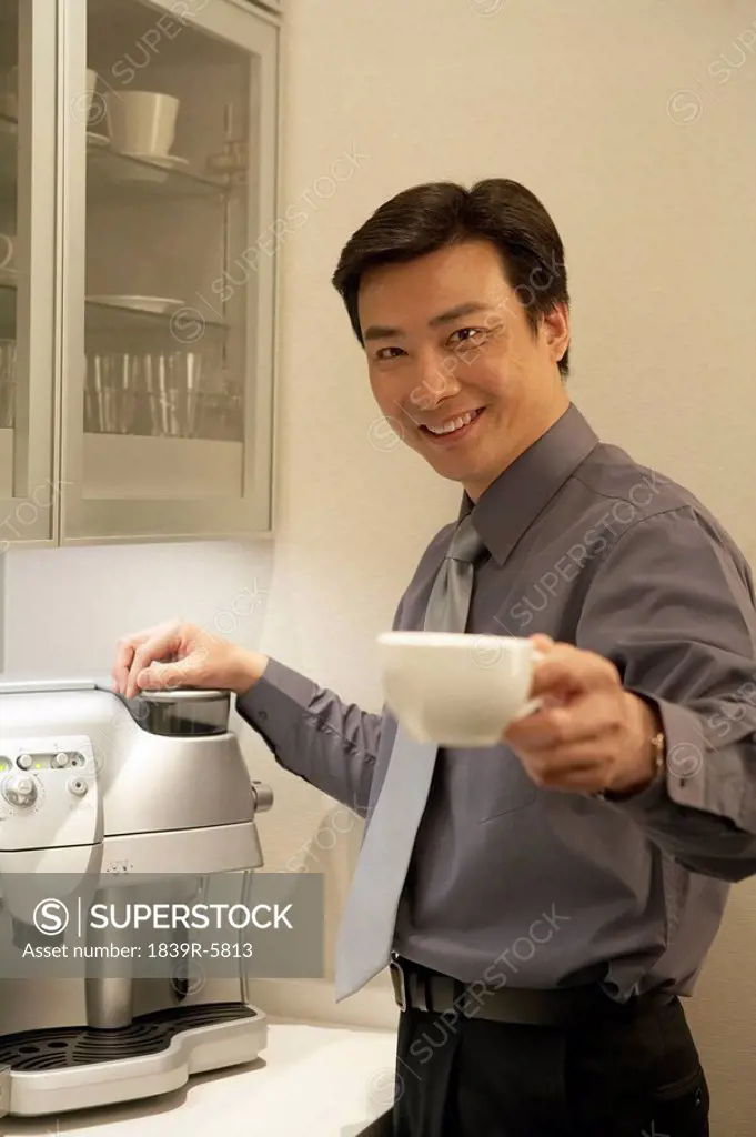 Young Man Making Coffee In Office
