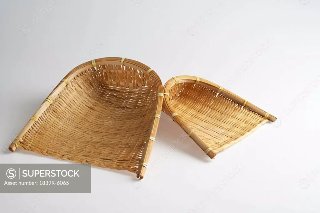 Two bamboo wicker scoops of varying sizes