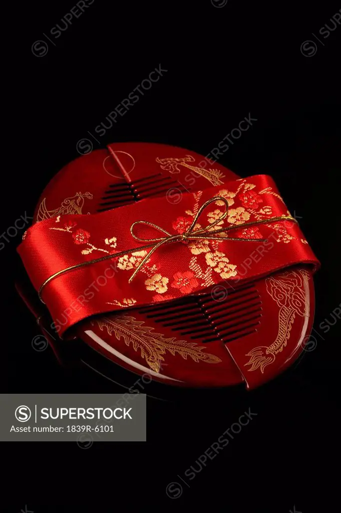 A set of red Chinese hair combs wrapped in a red ribbon