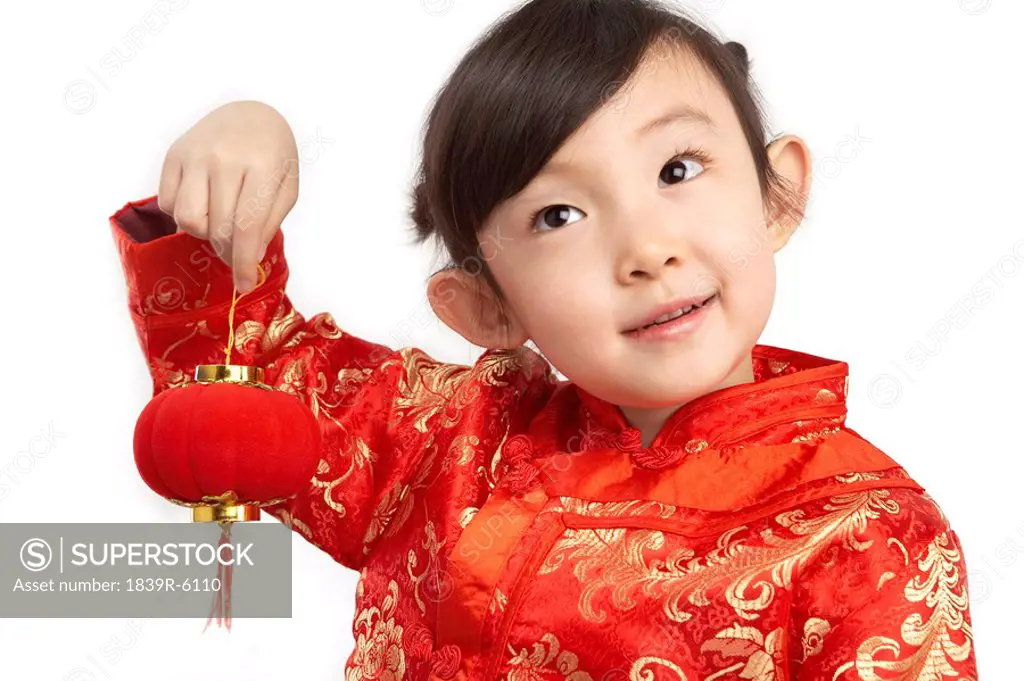 Young girl in festival Chinese New Year clothing, smiling, holding Chinese lantern