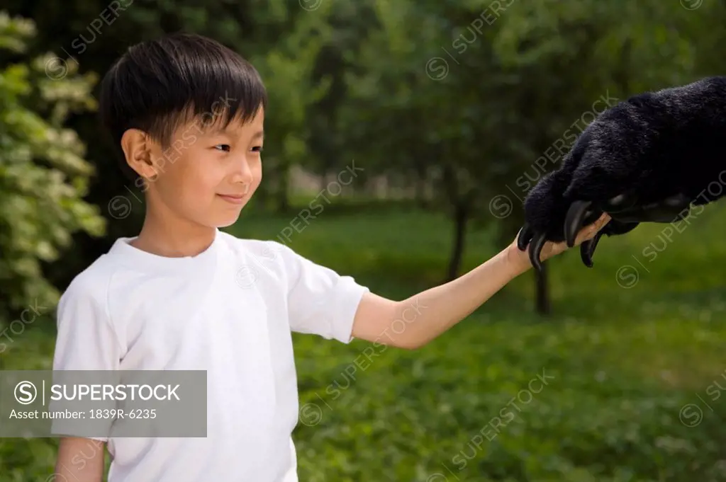 Young Boy Holding An Animal Paw
