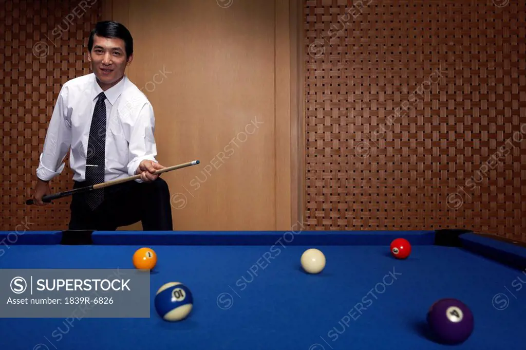 Portrait of a businessman at the billiards table