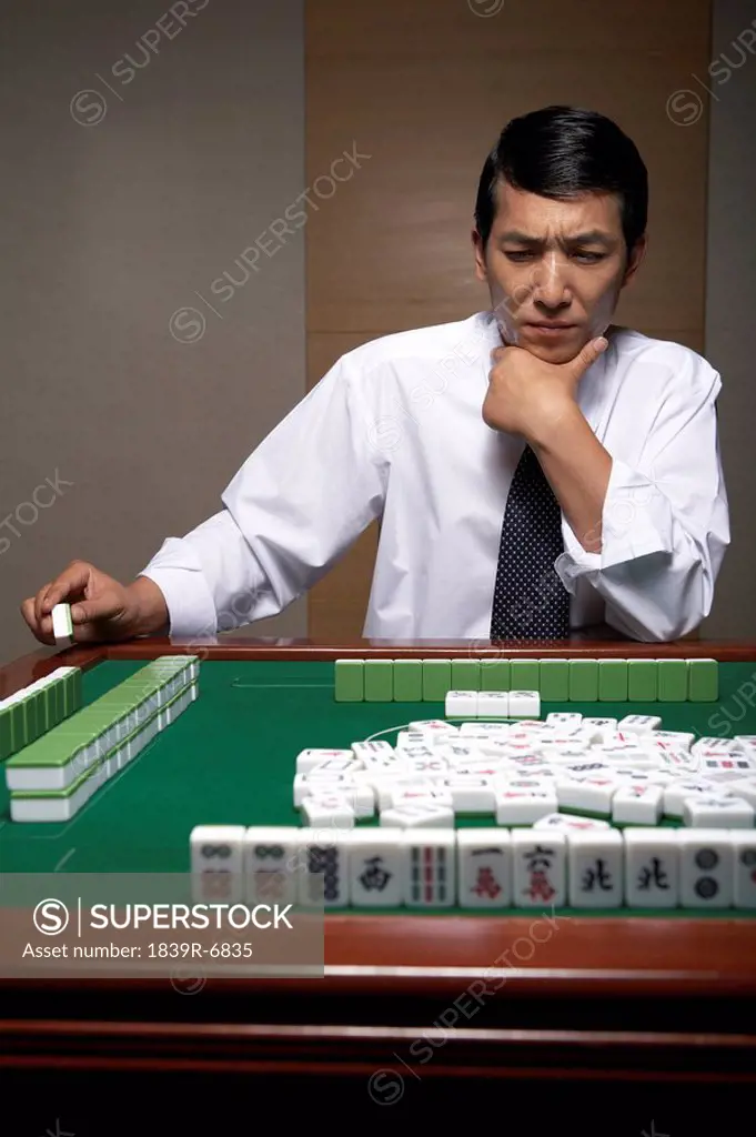 A businessman plays Mahjong