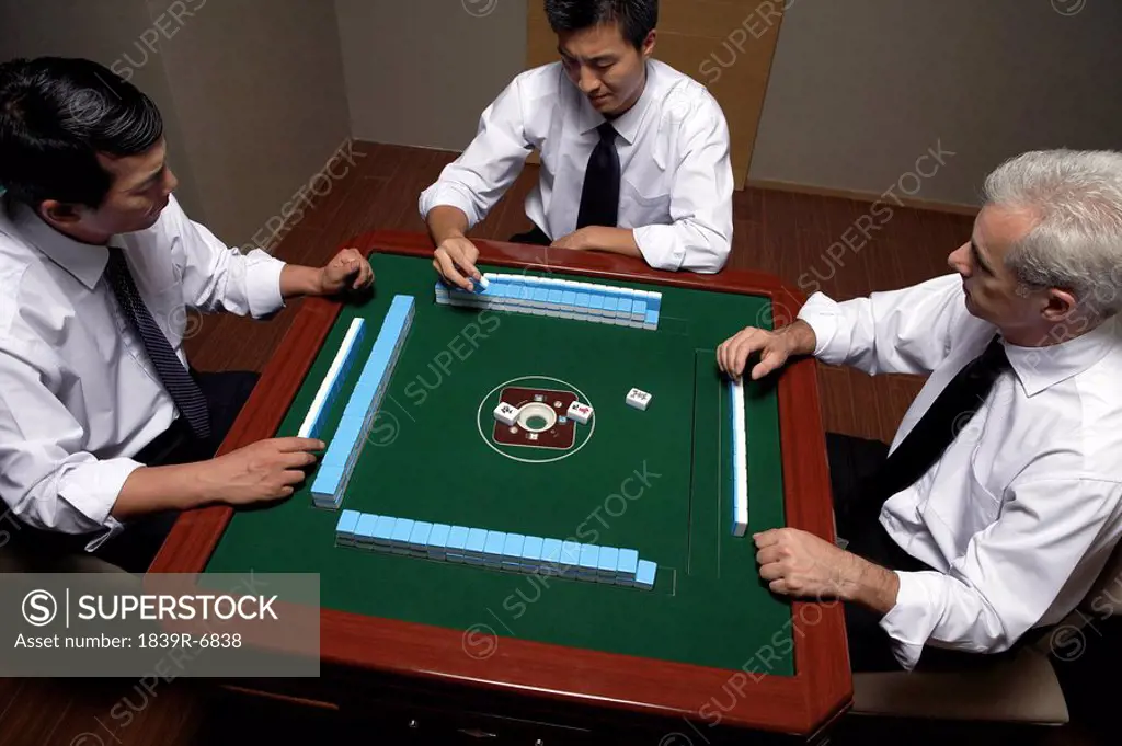 Three businessmen play Mahjong