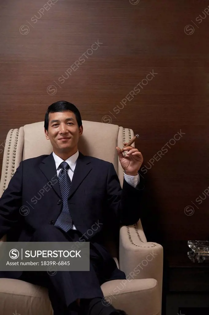 Successful businessman enjoys a cigar